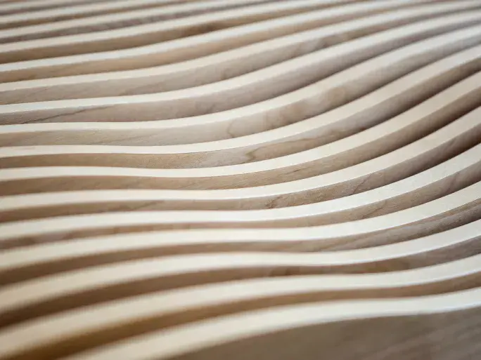 Close up shot of curved, hand-carved wood used for bespoke sound design in the offices and communal event spaces