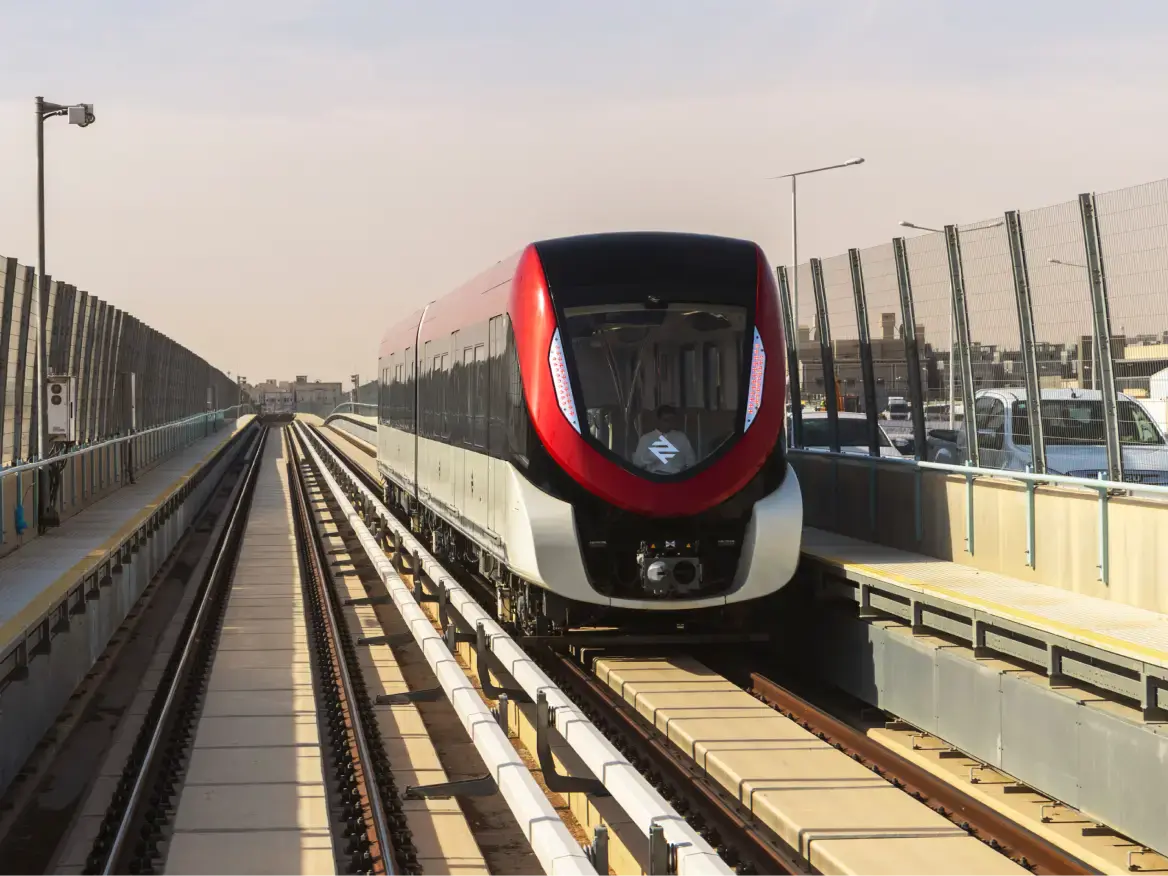 A red, black and silver train on the tracks.