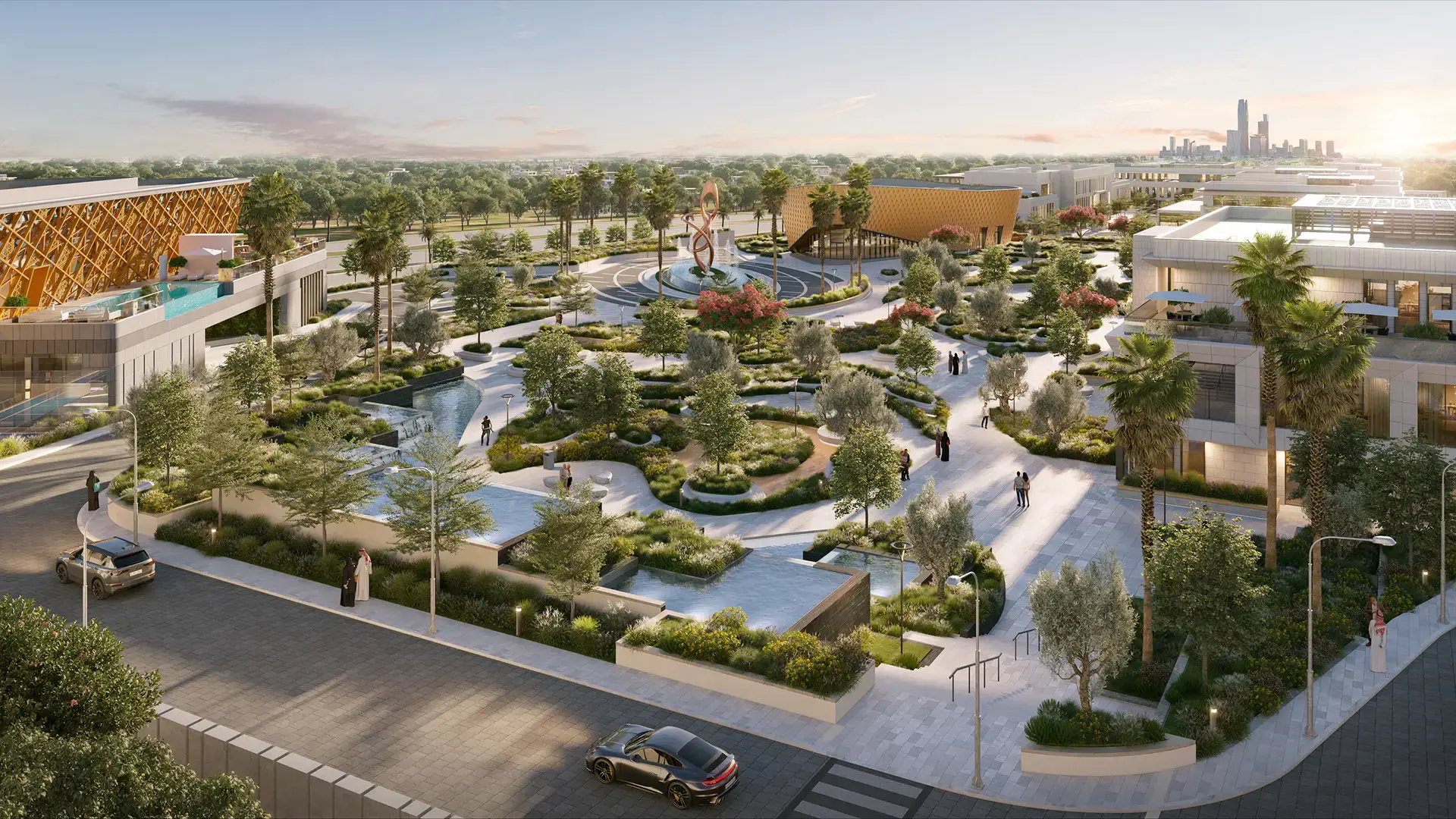 Modern urban park with landscaped greenery, walking paths, water features, palm trees, people, and surrounding buildings at sunset.